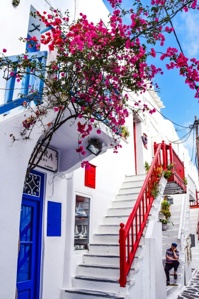 سلالم وزهور على جدار منزل أبيض في بلدة في اليونان